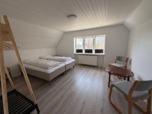 a room with a bed and a ladder and a chair at Harknakvej 19 BB in Bredebro