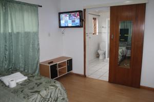 a bedroom with a bed and a tv and a bathroom at Tatami Guesthouse in Parow +65 photos