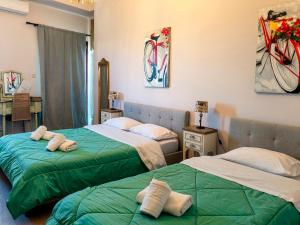 a bedroom with two beds with towels on them at Boutique Florence in Ermoupoli