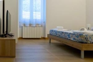 a bedroom with a bed and a window and a television at CadiSmart in La Spezia