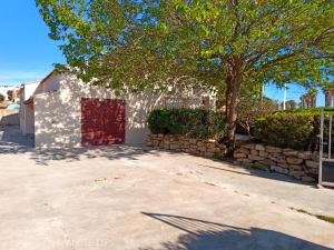 a building with a red door and a stone wall at La maison à la mer de Mamé Rosette in Port-de-Bouc +28 photos