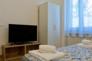 a bedroom with a tv and a bed with towels at CadiSmart in La Spezia
