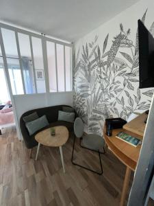 a living room with a couch and a table at Studio St Marc - plage à 300m in Saint-Nazaire +3 photos
