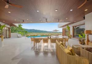 a dining room with a table and chairs and a pool at Villa Seresa Premium- La Union in Bacnotan