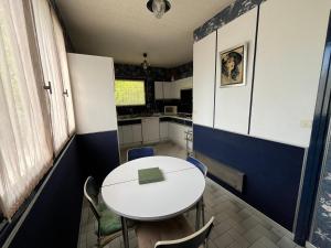 a small kitchen with a white table and chairs at Les Billardières - Suite familiale de 2 chambres entre Blois et Chambord, proche Loire à Vélo in Cour-sur-Loire