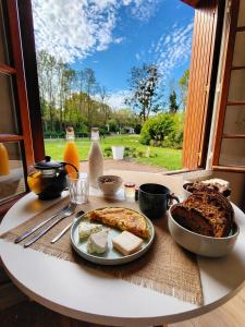 a table with a plate of food on a table with a window at L échappée verte in Gien
