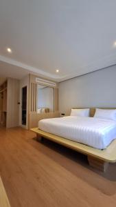 a bedroom with a large bed with a wooden bed frame at Destination Boutique Hotel in Pattaya