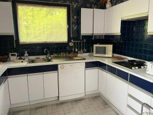 a kitchen with white cabinets and a sink and a window at Les Billardières - Suite familiale de 2 chambres entre Blois et Chambord, proche Loire à Vélo in Cour-sur-Loire