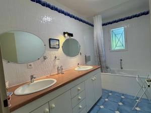 a bathroom with two sinks and a tub at La Maison du Square in La Teste-de-Buch +9 photos