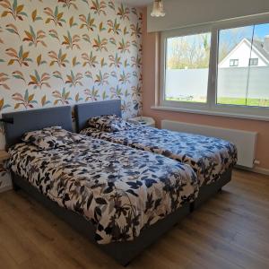 a bedroom with a bed with a floral wallpaper at Vakantiewoning Duinviooltje-Koksijde in Koksijde