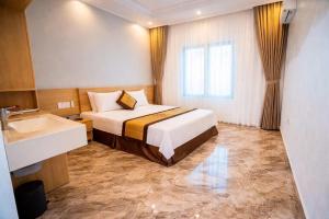 a hotel room with a bed and a sink at Serena Xuân Thành Hotel in Hà Tĩnh
