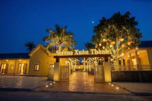 a building with a gate at night with christmas lights at Serena Xuân Thành Hotel in Hà Tĩnh