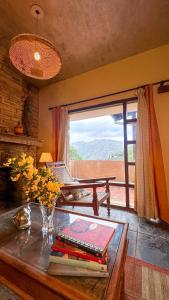 a room with a table with books and a window at Wild Meadows by Levitate - Exclusive Dual Bedroom Chalet Open Sky View & Fully Equipped Kitchen in Rāmgarh