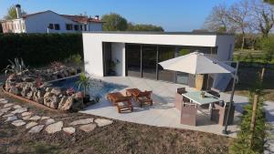 a patio with a table and an umbrella and a pool at The K Noir Private Pool Luxury Suite in Civé
