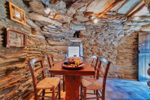 a table with a bowl of fruit in a stone room at The Vintage Dovecote in Mesariá +6 photos