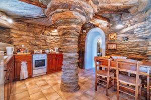 a kitchen with a stone wall and a table and chairs at The Vintage Dovecote in Mesariá