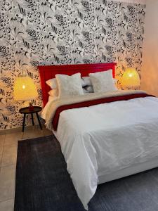 a bedroom with a white bed with a red headboard at Townside Estate UNIT8 in Ladysmith