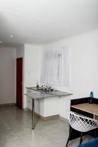 a kitchen with a sink and a table with a window at Townside Estate UNIT8 in Ladysmith