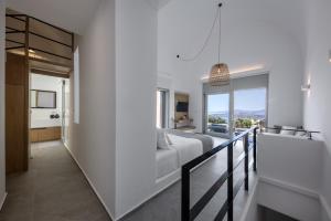 a bedroom with a bed and a balcony at Melidonia Suites in Akrotiri
