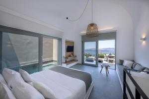 a bedroom with a bed and a view of the ocean at Melidonia Suites in Akrotiri +160 photos