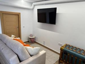 a living room with a couch and a television on a wall at El Rincón del Castillo I in Caravaca de la Cruz