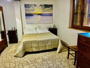 a bedroom with a bed and a painting on the wall at Affittacamere La Grotta Magica in Venagrande