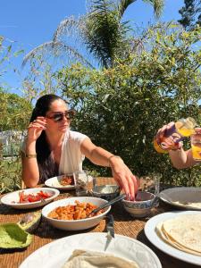 a woman sitting at a table eating food at Shifting Sands Surf House in Labenne