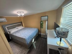 a bedroom with a bed and a desk and a mirror at Backyard Cottage in Naples