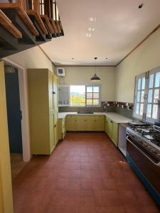 a large kitchen with yellow cabinets and a large window at The Amar Vilas in Dehradun