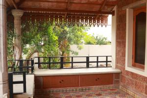 an outdoor porch with a pergola and a tree at SIENNA Ecr in Chennai +10 photos