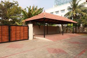 a pavilion with a roof on a brick patio at SIENNA Ecr in Chennai