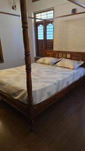 a bed with a wooden frame in a room at SIENNA Ecr in Chennai