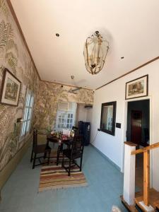 a dining room with a table and a chandelier at The Amar Vilas in Dehradun