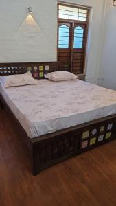 a large bed in a room with a wooden floor at SIENNA Ecr in Chennai