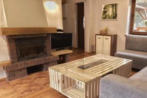 a living room with a coffee table and a fireplace at Domek Eve in Giżycko