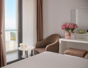 a room with two chairs and a table and a mirror at Sophia Central Nha Trang Hotel by HT in Nha Trang