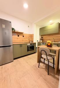 a large kitchen with a table and a refrigerator at Apartment Mey in Sarajevo