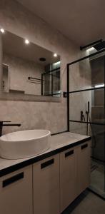 a bathroom with a sink and a glass shower at Celestial Luxury SKG Port in Thessaloniki
