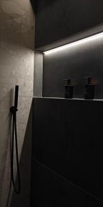 a black bathroom with a shower with a light at Celestial Luxury SKG Port in Thessaloniki