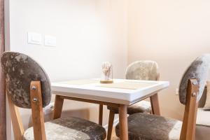 a table and four chairs with a vase on it at Modern Apartment with Balcony & Fast Wi-Fi & Self Check-in in Shkodër