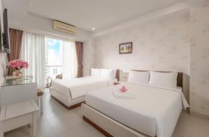 a hotel room with two beds and a window at Sophia Central Nha Trang Hotel by HT in Nha Trang +22 photos