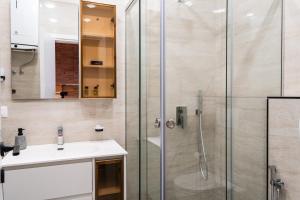 a bathroom with a glass shower and a sink at Modern Apartment with Balcony & Fast Wi-Fi & Self Check-in in Shkodër