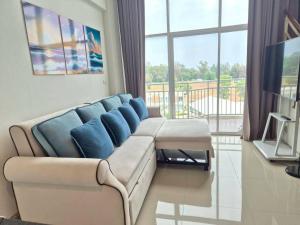 a living room with a couch and a large window at Mosaic condominium RoomBD64M in Klaeng