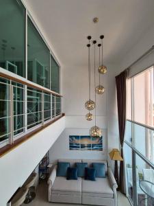 a living room with a couch and blue pillows at Mosaic condominium RoomBD64M in Klaeng +80 photos