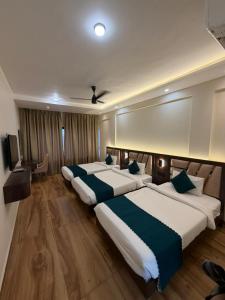a hotel room with two beds and a television at Hotel Navil Exotica in Chicalim
