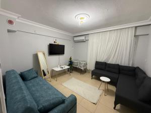 a living room with a blue couch and a tv at Liva Konukevi in Ayvalık +4 photos
