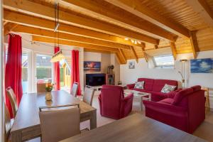 a living room with red chairs and a table at Ferienhaus Klapötke in Dorum