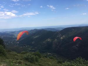 two kites flying in the sky over a mountain at Maison en pierre Ardèche du sud in Valgorge