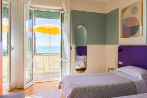 a bedroom with a bed and a balcony with an umbrella at Hotel Il Nido in Tellaro