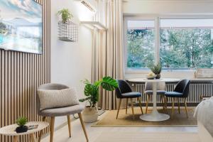 a living room with a table and chairs and a window at Charming Suite am Luganersee, Pool, Parkplatz in Bissone +25 photos
